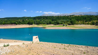 Peručko jezero Vrlika, Hrvatska: Ljudi se sunčaju na obali i plivaju u jezeru. na jezerskom pristaništu. Turisti na kajaku. Kupanje u Peručkom jezeru, Hrvatska.