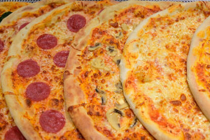 Ukusne pizza servirane u restoranu Ukusne pizza servirane u restoranu. Brza hrana. Mnogo različitih vrsta italijanskih pica na stolu.