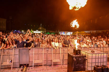 Publika na rok koncertu Grupa mladih ljudi pjeva i pleše na koncertu. Publika ispred bine na muzičkom festivalu. Ljubitelji muzike uživaju u rok koncertu. Plamen. Mostar summer fest.
