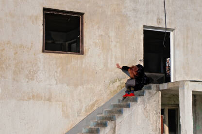 Romkinja plače za svojom kućom, dok je pored nje nova zgrada. 

Fotografija besplatna za ilustrovanje medijskih sadržaja o Romima, svako drugo korištenje je zabranjeno. 

Autorka: Svjetlana Panić