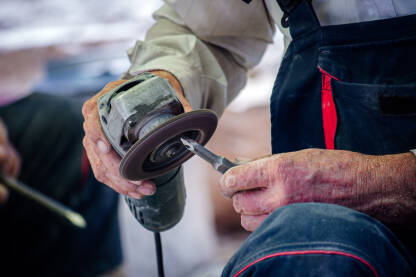 Radnik sa brusilicom oštri dlijeto
