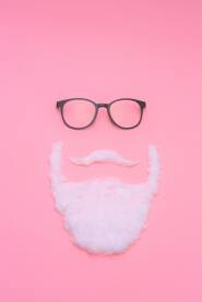 Čovjek sa naočalama Muškarac sa crnim naočalama, biijelim brkovima i bradom na roze, pink podlozi, hipster, koncept