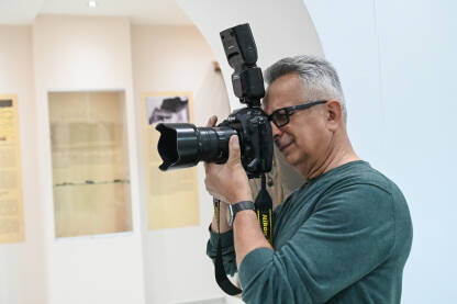 Fotograf snima fotografije. Fotograf snima fotografije. Profesionalni fotograf na događaju.