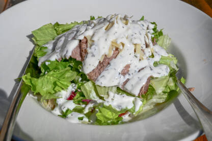 Obrok salata sa mesom Svježa salata sa goveđim biftekom. Mješavina svježih salata, posuta sirom i jogurtom sa začinskim biljem