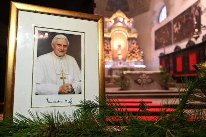 Fotografija pape Benedikta XVI izložena u crkvi Fotografija pape Benedikta XVI izložena u crkvi nakon njegove smrti. Papa Benedikt XVI bio je poglavar Katoličke crkve. Joseph Aloisius Ratzinger.