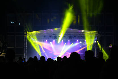 Publika ispred bine Publika ispred bine na festivalu. Ljubitelji muzike na rock koncertu. Rasvjeta i osvjetljenje pozornice tokom muzičkog koncerta.