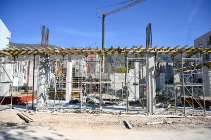 Gradilište u gradu. Radnici na gradilištu. Gradilište u gradu. Radnici na gradilištu. Izgradnja stambene zgrade. Skele, beton, kranovi i armatura na gradilištu.