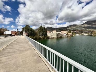 Širokougaona fotografija Trebišnjice i Starog grada Trebinje Trebišnjica i Stari grad Trebinje. Na fotografiji su vidljivi Saborni hram u Trebinju, Stari grad Trebinje. Vidljivi su i most Ive Andrića sa lijeve i Kameni most sa desne strane fotografije.
