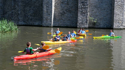 Turisti u kajaku na rijeci. Ljudi voze kajak i istražuju.