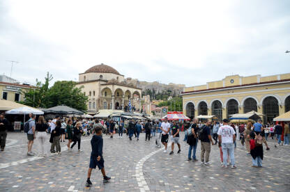Atina, Grčka: Ljudi šetaju Trgom Monastiraki u Atini. Turisti istražuju grad. Arhitektura u starom gradu. Džamija Tzistarakis.