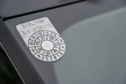 Naljepnica na vjetrobranskom staklu automobila Naljepnica na vjetrobranskom staklu automobila u Austriji. Potvrda o registraciji.