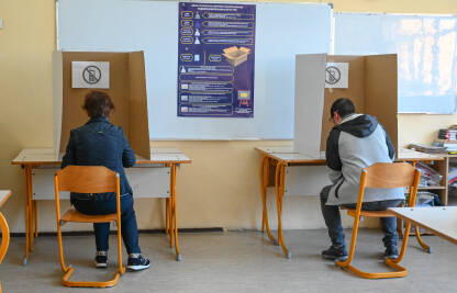 Ljudi glasaju na izborima. Glasači u kabinama.