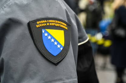 Grb BiH na uniformi policajca Suda BiH. Amblem na uniformi policajca. Grb BiH. Natpis Bosna i Hercegovina na uniformi policajca Suda BiH. Sud Bosne i Hercegovine.