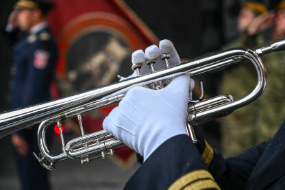 Muzičar svira trubu Muzičar svira trubu. Vojnik u bijelim rukavicama svira trubu. Vojni orkestar na paradi.