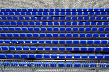 Plastične plave stolice na tribinama stadiona. Plastične plave stolice na tribinama stadiona. Redovi stolica za publiku.