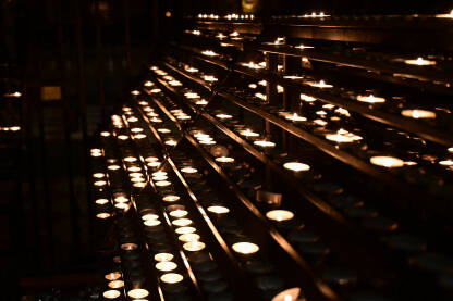 Svijeće gore u crkvi. Zapaljene svijeće u crkvi. Upaljene molitvene svijeće unutar katoličke katedrale.