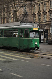 Stari zeleni tramvaj Deo zelenog tramvaja fotografisan u pokretu, Velika zgrada u pozadini