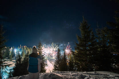 Žena posmatra vatromet na planini