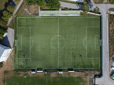 Fudbalski stadion, snimak dronom. Fudbalski stadion, snimak dronom. Zeleni sportski teren. Vještačka trava na stadionu. Sportski teren. Bijele linije na terenu stadiona.