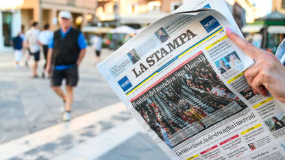 Novine La Stampa, Italija Djevojka drži novine na ulici. Osoba čita novine. Italijanska štampa. La Stampa.