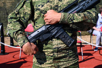 Vojnik u uniformi drži automatsku pušku. Vojnik u uniformi drži automatsku pušku. Specijalne snage sa oružjem.