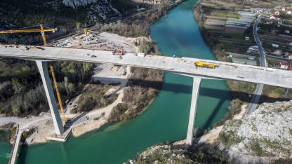Izgradnja visokog mosta preko rijeke. Autoput Vc. Izgradnja visokog mosta preko rijeke, snimak dronom iz zraka. Radnici i mašine na gradilištu. Most na autoputu. Most preko Neretve kod Počitelja. Autoput Vc.