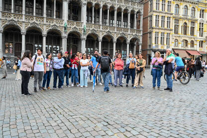 Brisel, Belgija: Grupa turista na glavnom trgu. Brisel, Belgija: Grupa turista na glavnom trgu. Ljudi istražuju grad.