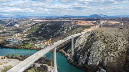 Izgradnja visokog mosta preko rijeke, autoput Vc kod Počitelja Izgradnja visokog mosta preko rijeke, snimak dronom. Radnici i mašine na gradilištu. Most na autoputu Vc kod Počitelja, BiH.