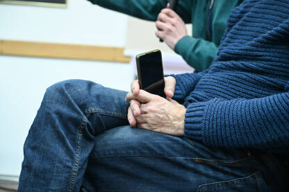 Čovjek drži mobilni telefon u rukama. Čovjek drži mobilni telefon u rukama.