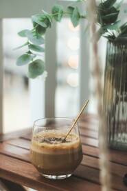 Kava Homemade espresso kava u staklenoj čaši sa zlatnom kašikom. Detalji ljetne večeri. Fokus je na detaljima, uz "soft look" i bokeh.