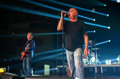 Zoran Kostić Cane sa bendom Partibrejkers na koncertu. Zoran Kostić Cane pjeva na bini na koncertu. Cane je rock glazbenik i pjevač rock grupe Partibrejkers.