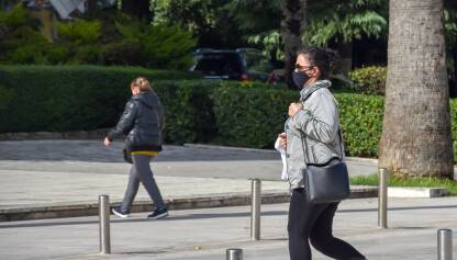 Žena hoda ulicom sa maskom na licu zbog prevencije širenja virusa korona.
