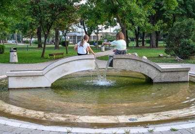 Djevojčice se igraju u fontani u parku. Djevojčice se igraju sa vodom u fontani u parku. Fontana u parku u Mostaru.
