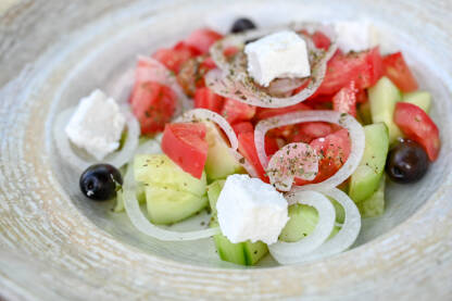 Svježa salata restoranu. Grčka salata Svježa salata servirana u restoranu. Grčka salata u tanjiru. Paradajz, luk, krastavac i sir.
