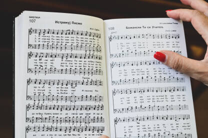 Vjerske pjesme, Hrišćanska adventistička crkva Žena moli u crkvi. Djevojka drži knjigu molitvenih himni tokom mise. Vjernici se mole.