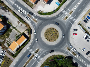 Saobraćaj u kružnom toku u gradu, snimak dronom. Kružni tok u gradu, snimak dronom. Automobili se kreću. Saobraćaj u kružnom toku u gradu. Prijevoz.