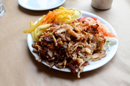 Döner kebab. Tradicionalni doner kebab serviran na tanjiru. Popularno jelo od mesa pečenog na vertikalnom ražnju.