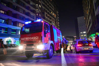 Vatrogasci i vatrogasni kamioni u blizini požara. Profesionalna vatrogasna jedinica Kantona Sarajevo. Vatrogasci i vatrogasni kamioni u blizini požara. Svjetla vatrogasnog kamiona bljeskaju noću. Grupa vatrogasaca na intervenciji. Profesionalna vatrogasna jedinica Kantona Sarajevo.