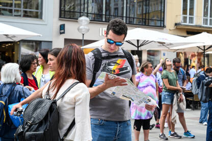 Turisti gledaju u kartu Turisti gledaju u kartu tokom razgledavanja grada. Turistička tura.