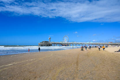 Scheveningen, Den Haag, Nizozemska: Ljudi na plaži. Scheveningen, Den Haag, Nizozemska: Ljudi na plaži. Mol u Sjevernom moru u Hagu. Turisti na pješčanoj plaži.