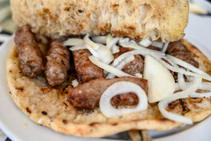 Ćevapi sa lukom u somunu. Ćevapi sa lukom u somunu. Tradicionalno jelo Balkana. Ukusni ćevapi u lepinji.