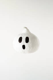 Bijela tikva s nacrtanim strašnim licem Bijela tikva s nacrtanim strašnim licem duha koja lebdi u zraku. Halloween. Noć vještica.