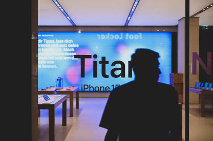 Izlog Apple shopa u gradu noću. Nedavno objavljen iPhone 15. Izlog Apple shopa u gradu noću. Nedavno objavljen iPhone 15. Titanium. Prodavnica pametnih telefona reklamira novi model telefona.