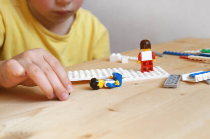 Lego Dječak koji se na stol igra sa lego kockicama.