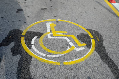 Znak za parking za osobe sa invaliditetom. Znak za parking za osobe sa invaliditetom. Parking rezervisan za osobe sa invaliditetom. Simbol invalidskih kolica na asfaltu.