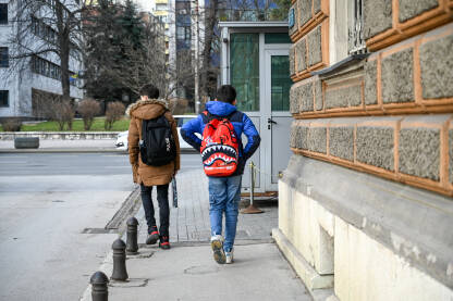 Učenici sa torbama se vraćaju kući iz škole. Učenici sa torbama se vraćaju kući iz škole. Dječaci sa torbama šetaju gradom. Školarci nakon nastave.