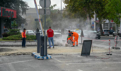 Radnici rade na asfaltiranoj cesti. Radnici rade na asfaltiranoj cesti u gradu. Radnici u kombinezonima sijeku i postavljaju ivičnjake.