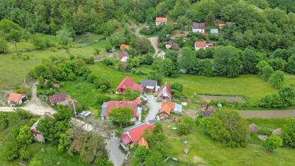 DJI_0010 Stare kuće u selu u proljeće. Zeleno drveće i livade u selu. Tradicionalne kuće i štale u prirodi, snimak dronom.