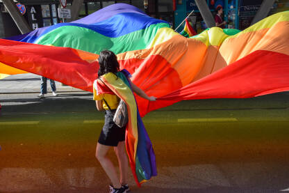 Dugina zastava Djevojka drži ogromnu LGBT, duginu zastavu na Povorci ponosa 2022.