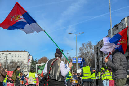 Mladić obučen u srpsku narodnu nošnju, sa zastavom Srbije. Studenti na protestima. Studenti blokiraju Autokomandu 27.01.2025. u Beogradu.
